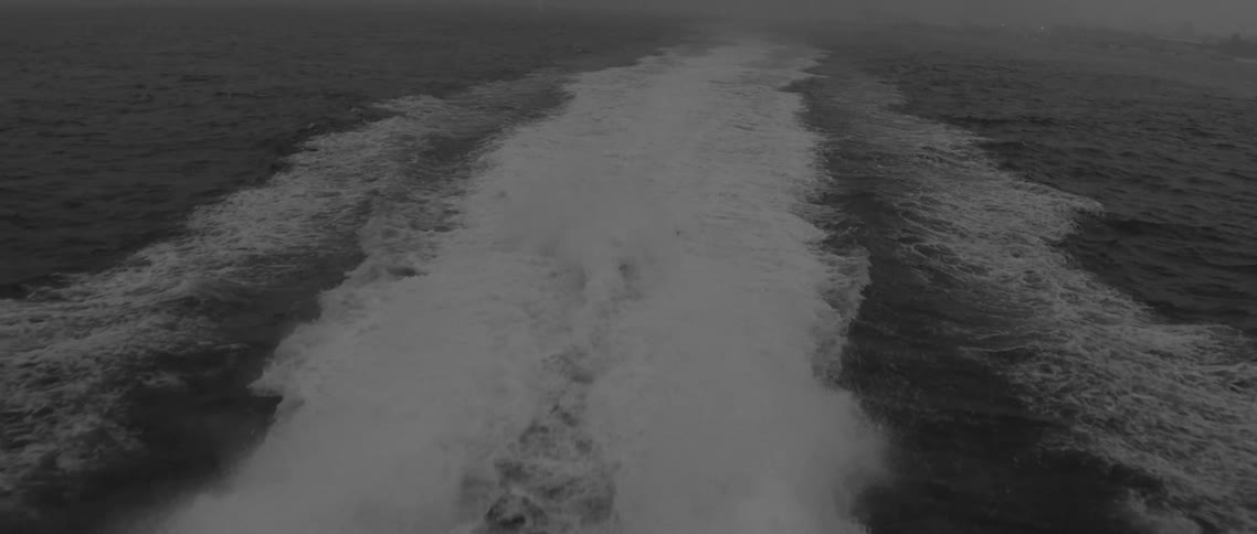 The foaming wake from a ferry in the ocean on cloudy day