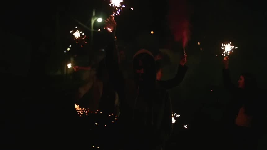 A group of people holding burning sparklers