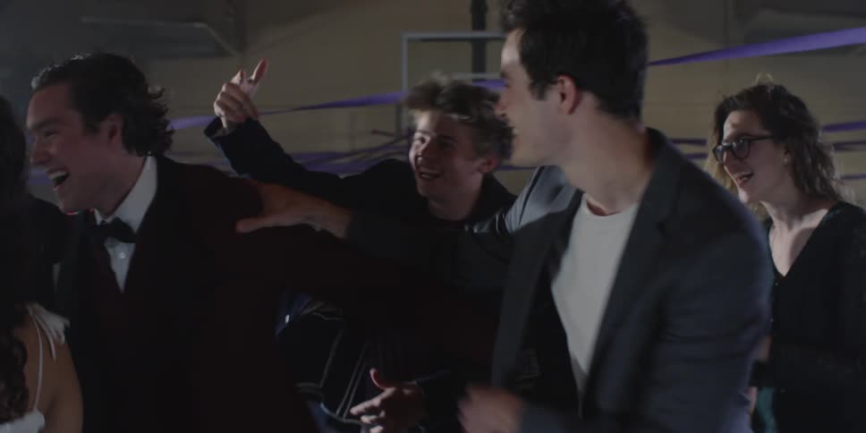A group of teenagers laugh and dance together