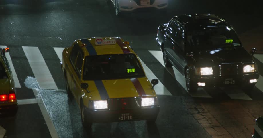 Many vehicles driving down a city street at night