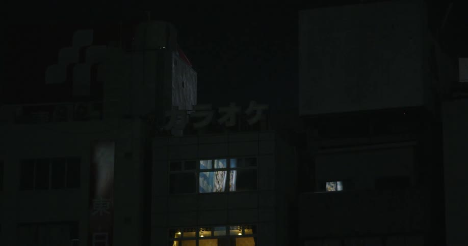 Flashing sign sits near the roof of a building