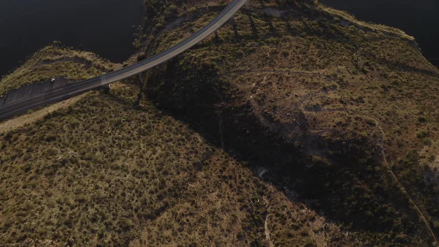 The bridge gaps the hills and water below