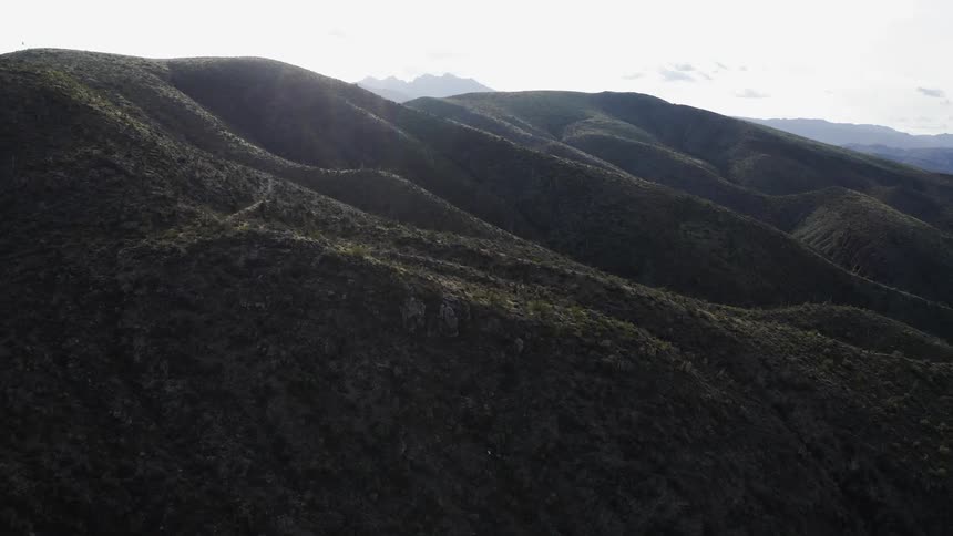 Numerous hills sit under the bright sky