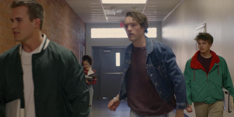 The teenagers walk together down the school hall