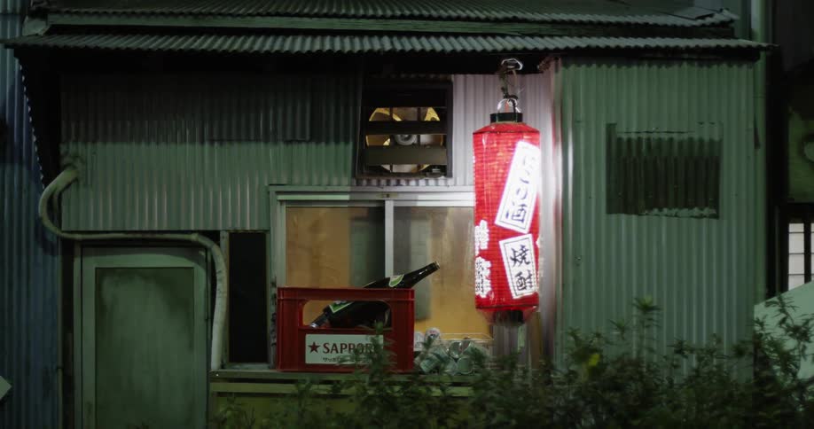 The lamp outside of the building is bright at night