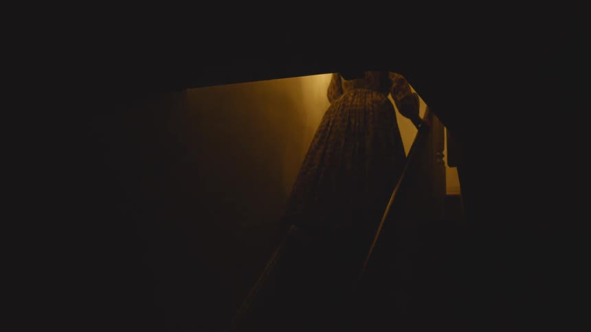 A woman travels up the dark steps