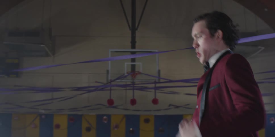 Man dances in a gym decorated with streamers