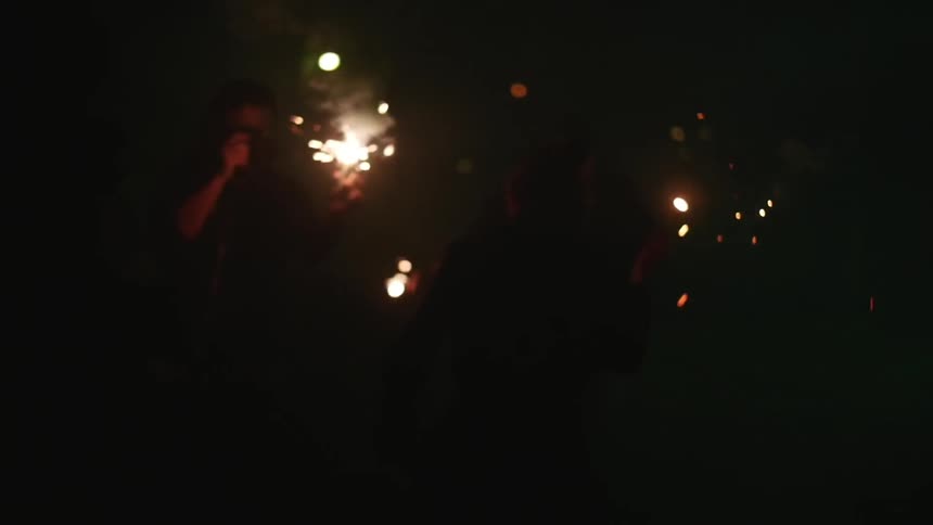 People lighting off fireworks at night
