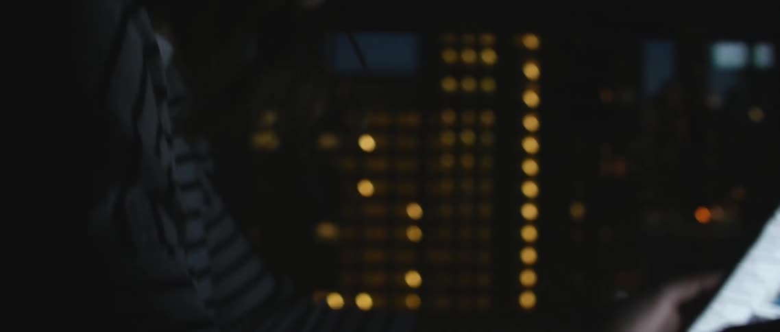 A woman looks at a tablet at night