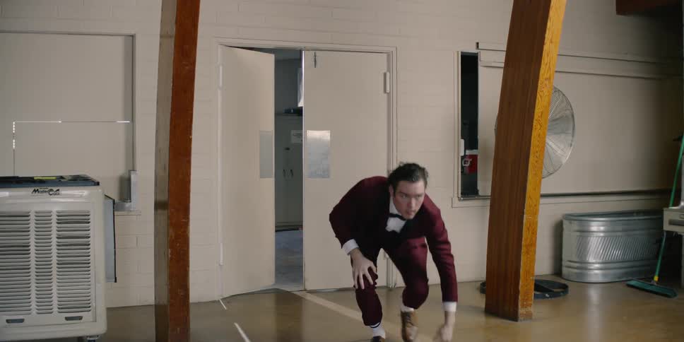 Man opens a door and trips gets up and walks away