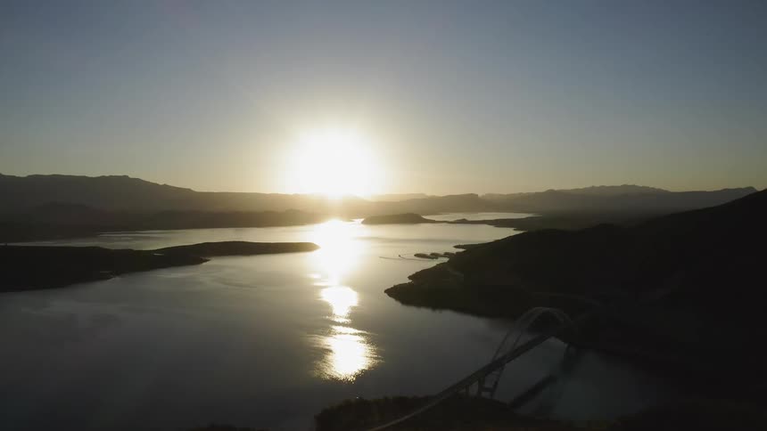 Sun rises over a wide river and hills