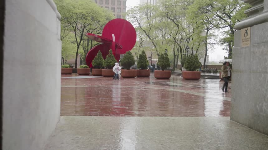 People walking across a plaza on a rainy day
