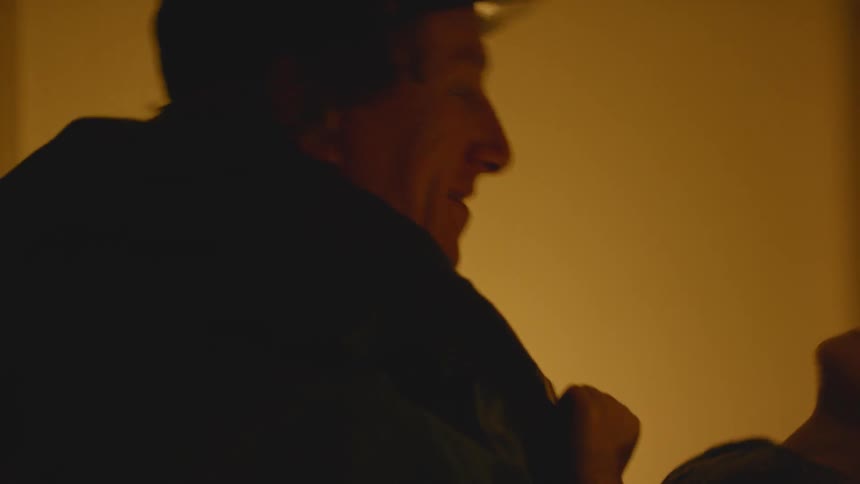 Man wearing a hat holds a young child in his arms