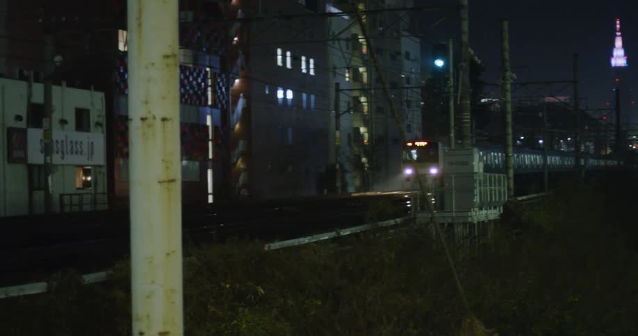 A subway train carrying passengers travels through a city at night