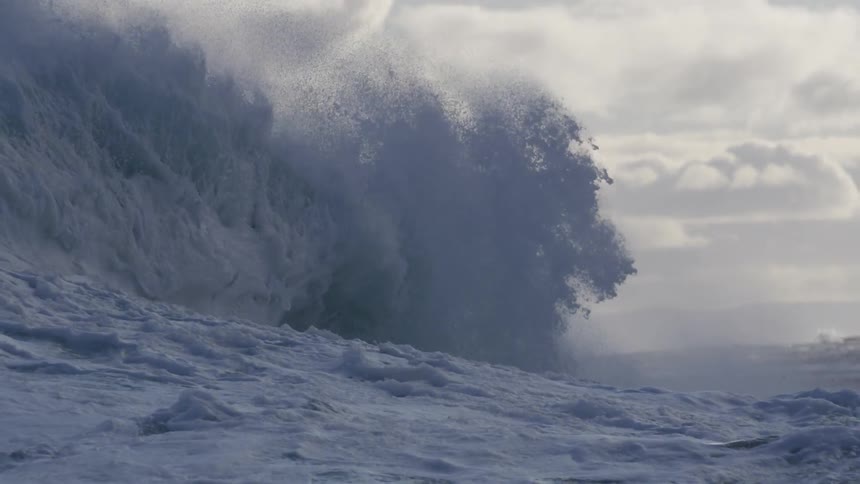 A close up of an ocean wave as a crests and then crashes down