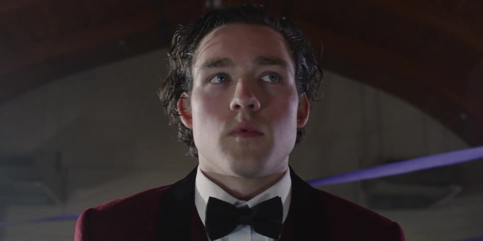 Man wearing a bow tie breathes in and out as he looks around
