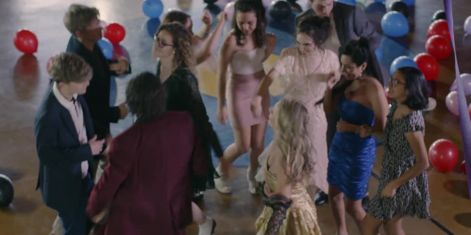 A group of teenagers dance together in the gym