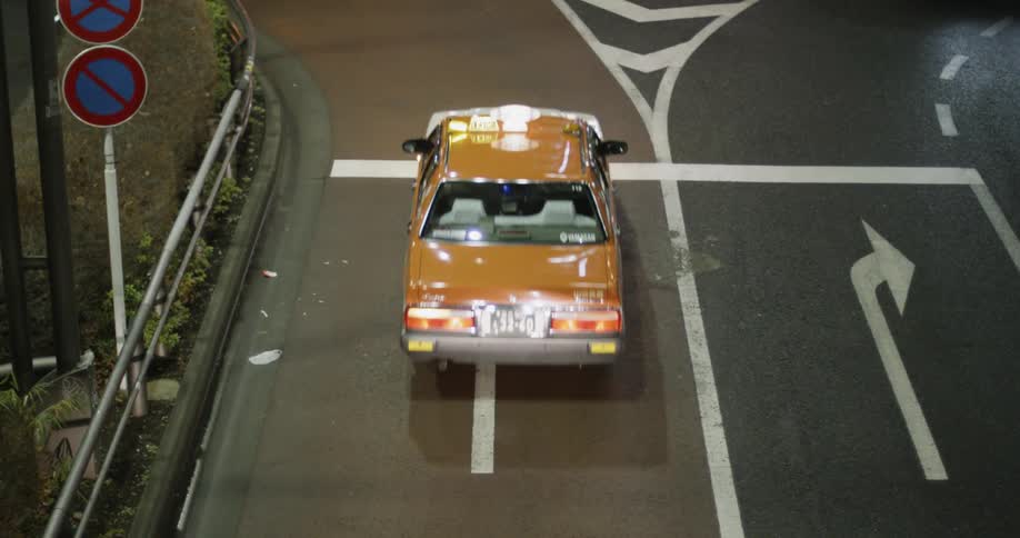 A taxi cab leads traffic on a left turn after a stop