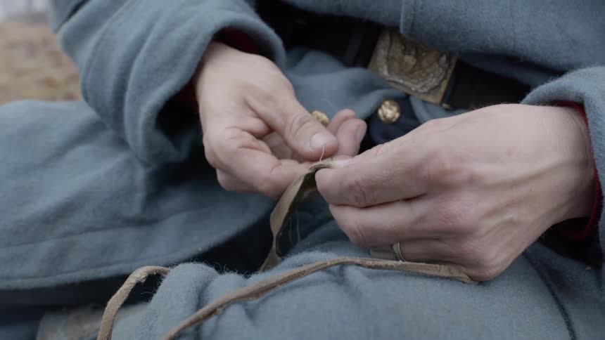 Person sews a small piece of rope together