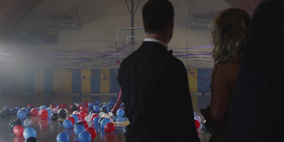 Man dances in a gym decorated with streamers