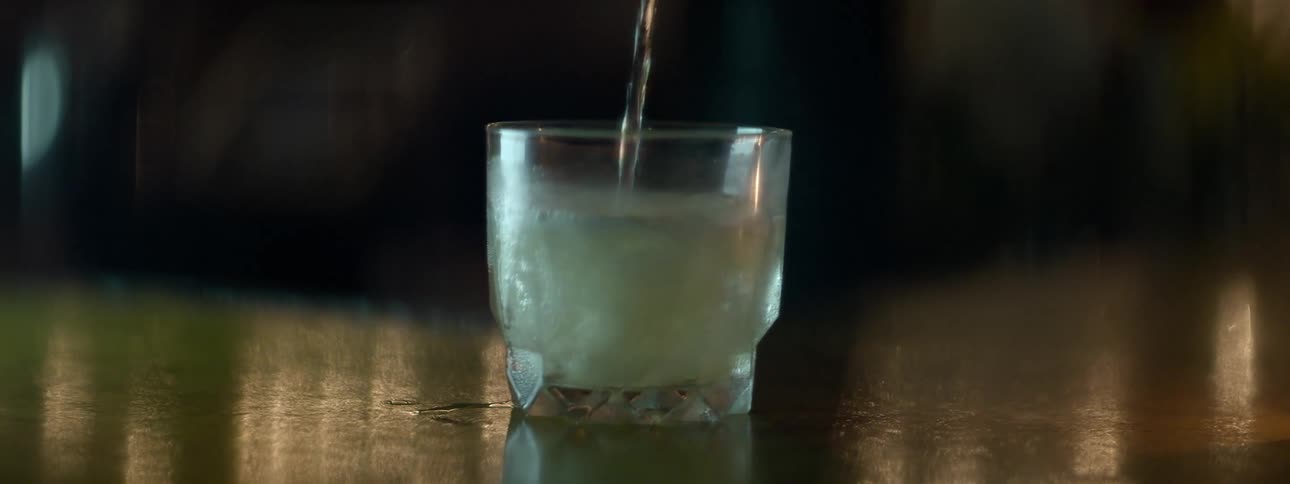 A drink is poured over ice in a glass
