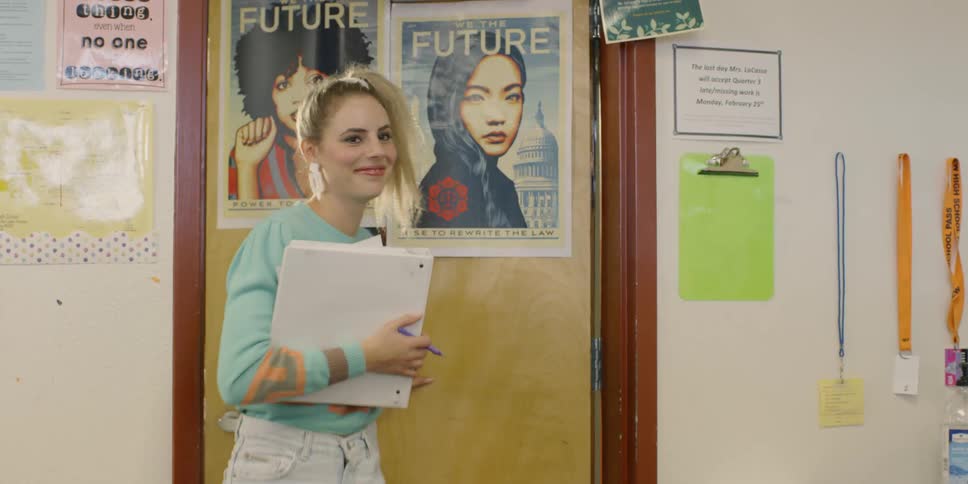 A girl enters the classroom smiling