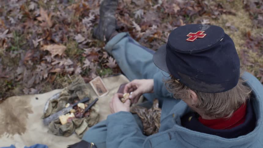 A man sits down having some food in the leaves