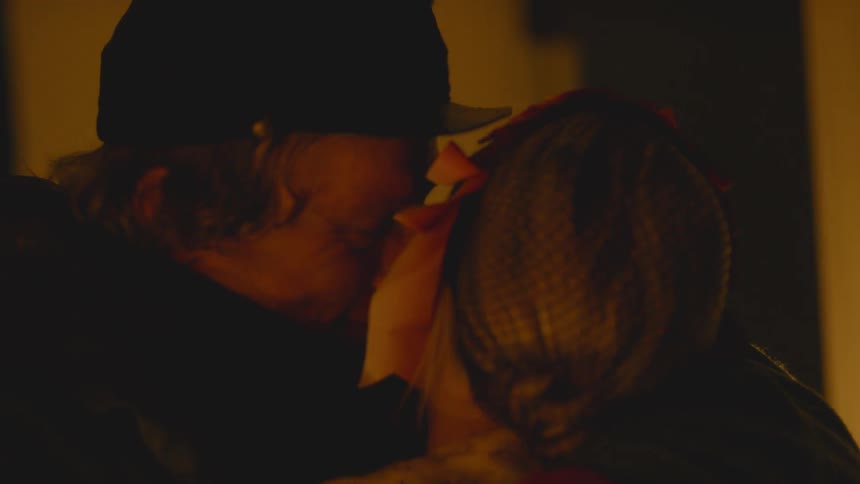 A soldier laughs and kisses his wife