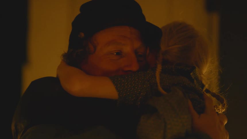 A soldier picks up his daughter and kisses her