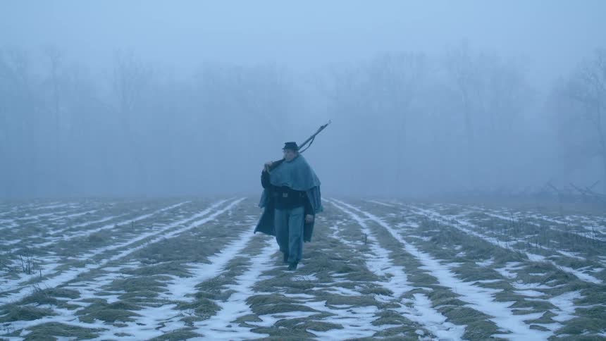 A man hikes over the snow covered field