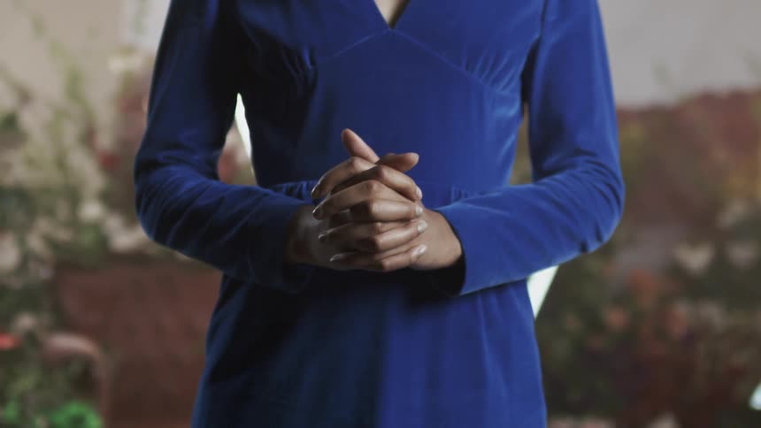 A woman clenches her hands together