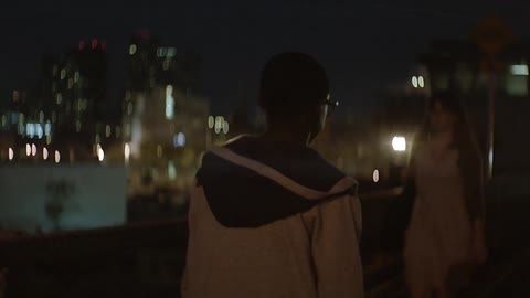 Man walks down a city street towards blinking light