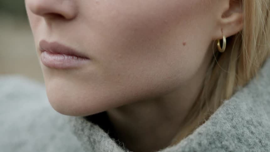 A woman is staring as she stands outside on a cold day