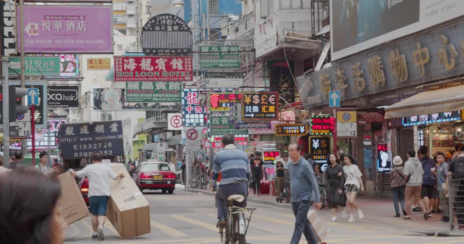 The busy city street has many vehicles and people traveling