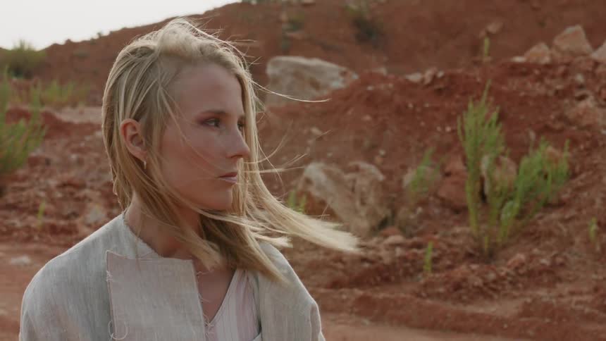 Blond woman turns her head as the wind blows her hair