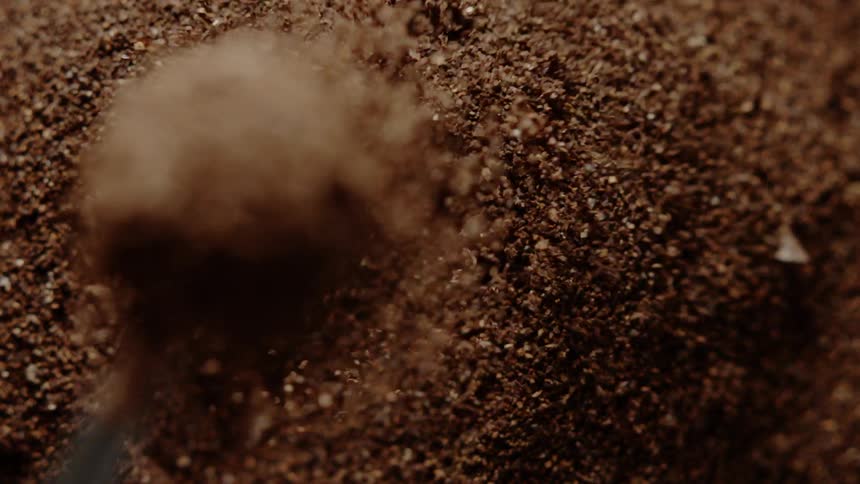 Scooper drops in a pile of coffee grounds