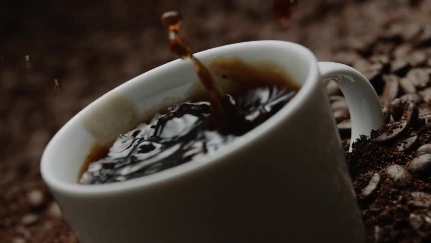 Mug filled with coffee in a large pile of coffee beans