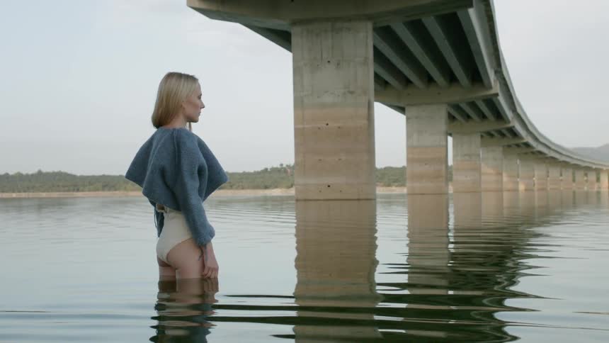 A woman is sanding knee high in the water