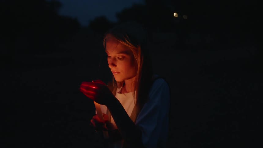 A woman is guarding a candle at night