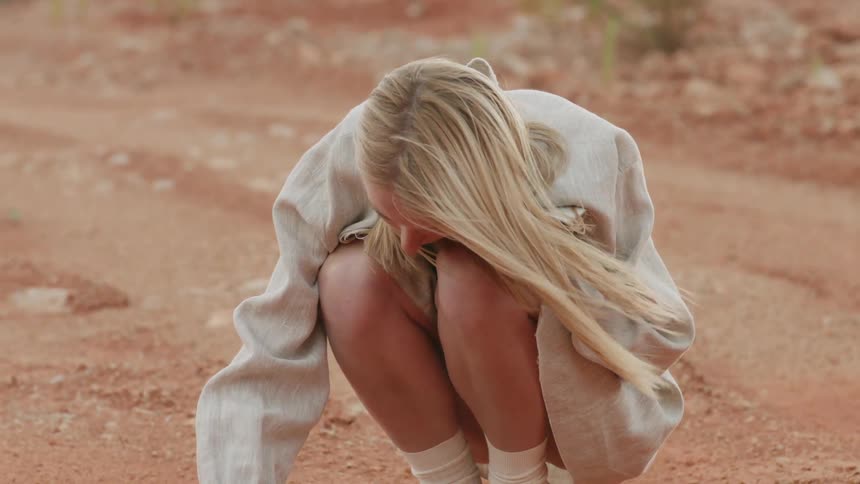 Woman kneels in the dirt