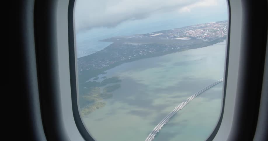 A plane flies above the clear water