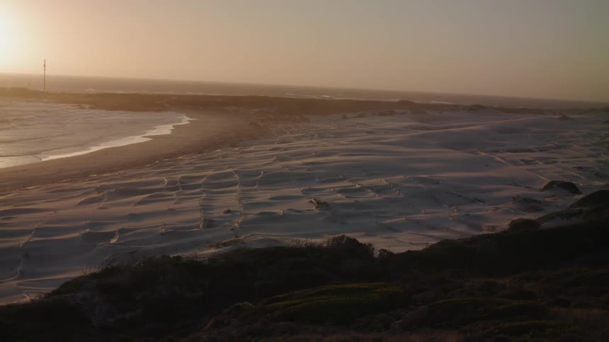 The waves slowly hit the shore at dawn