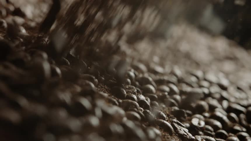 Coffee beans and grounds pour down into a large pile
