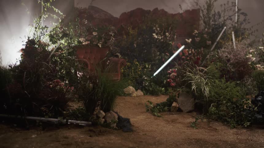 Lights flicker on a film site with many plants and flowers