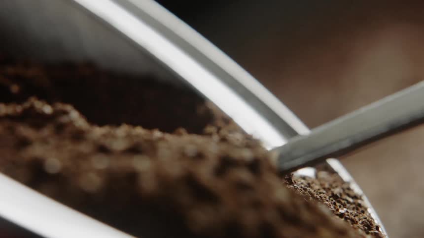 Ground coffee being scooped from a container