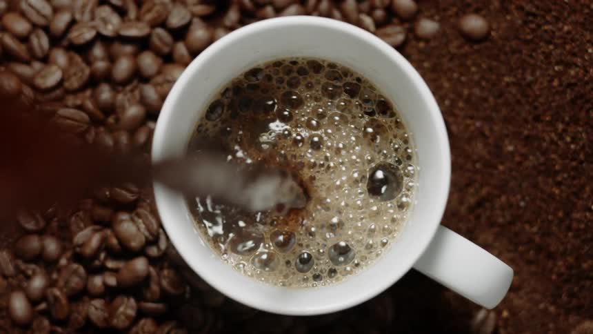 Coffee is being poured into a coffee cup