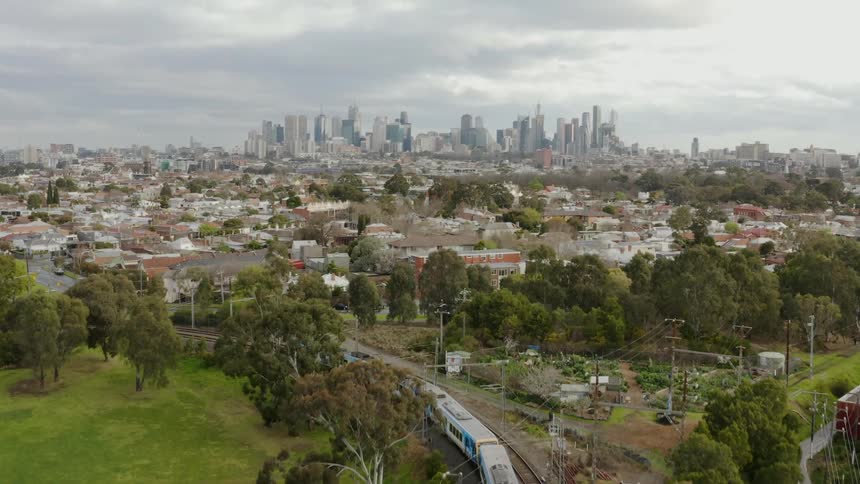 Train travels down the tracks towards a city