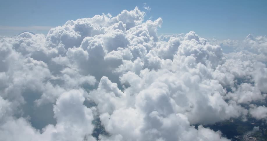 Clouds are billowing and drifting in the sky in daylight