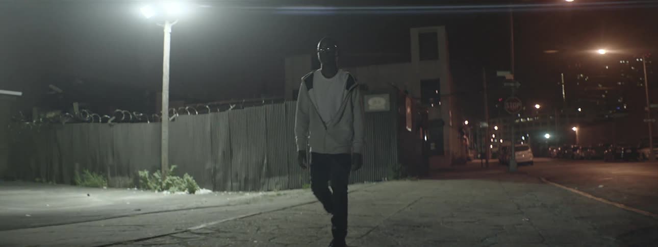Boy walking down a street at night