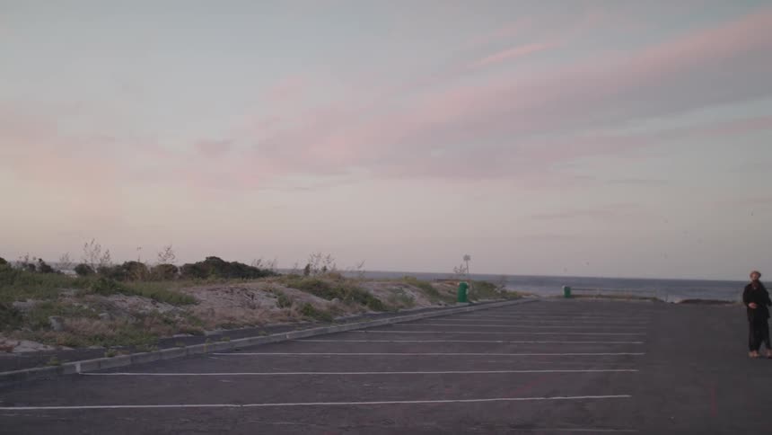 Man and woman embrace as they stand in a parking lot